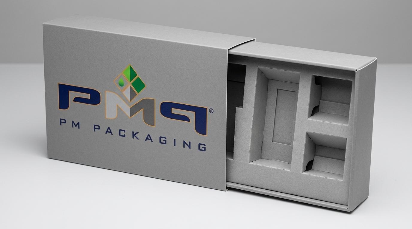 Drawer box with inner tray partially extended revealing modular interior paperboard insert cavities with PM Packaging logo