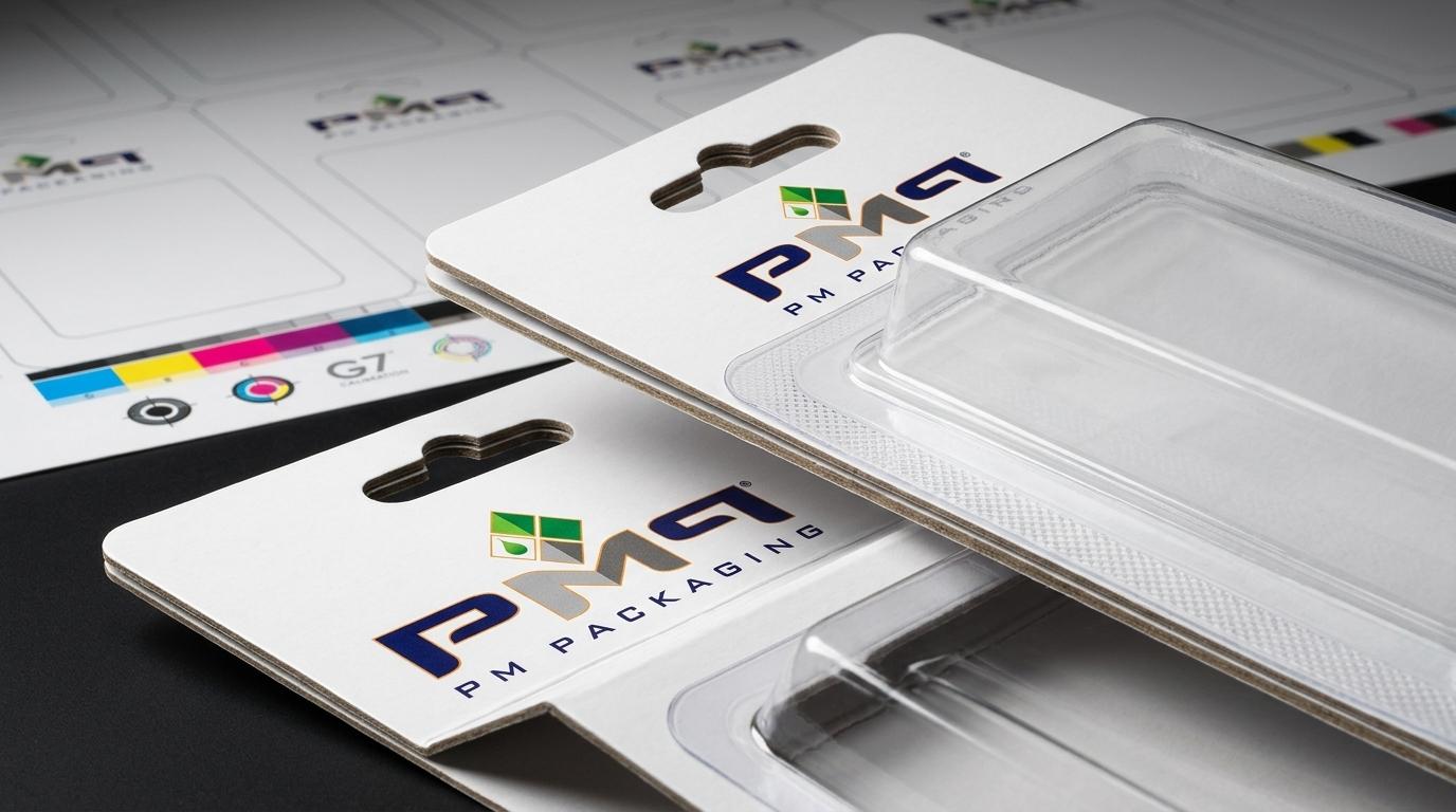 Commercial paperboard trapped blister cards with thermoformed transparent RPET cavities, Sombrero hang tabs, and official PM Packaging branding