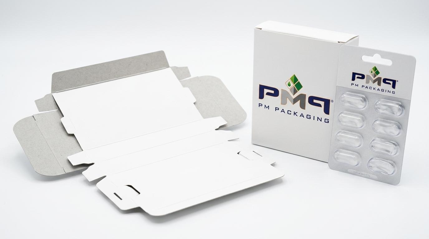 Unfolded precision paperboard folding carton die-cut blank alongside an assembled SBS carton and empty qikCombo blister card with PM Packaging logo